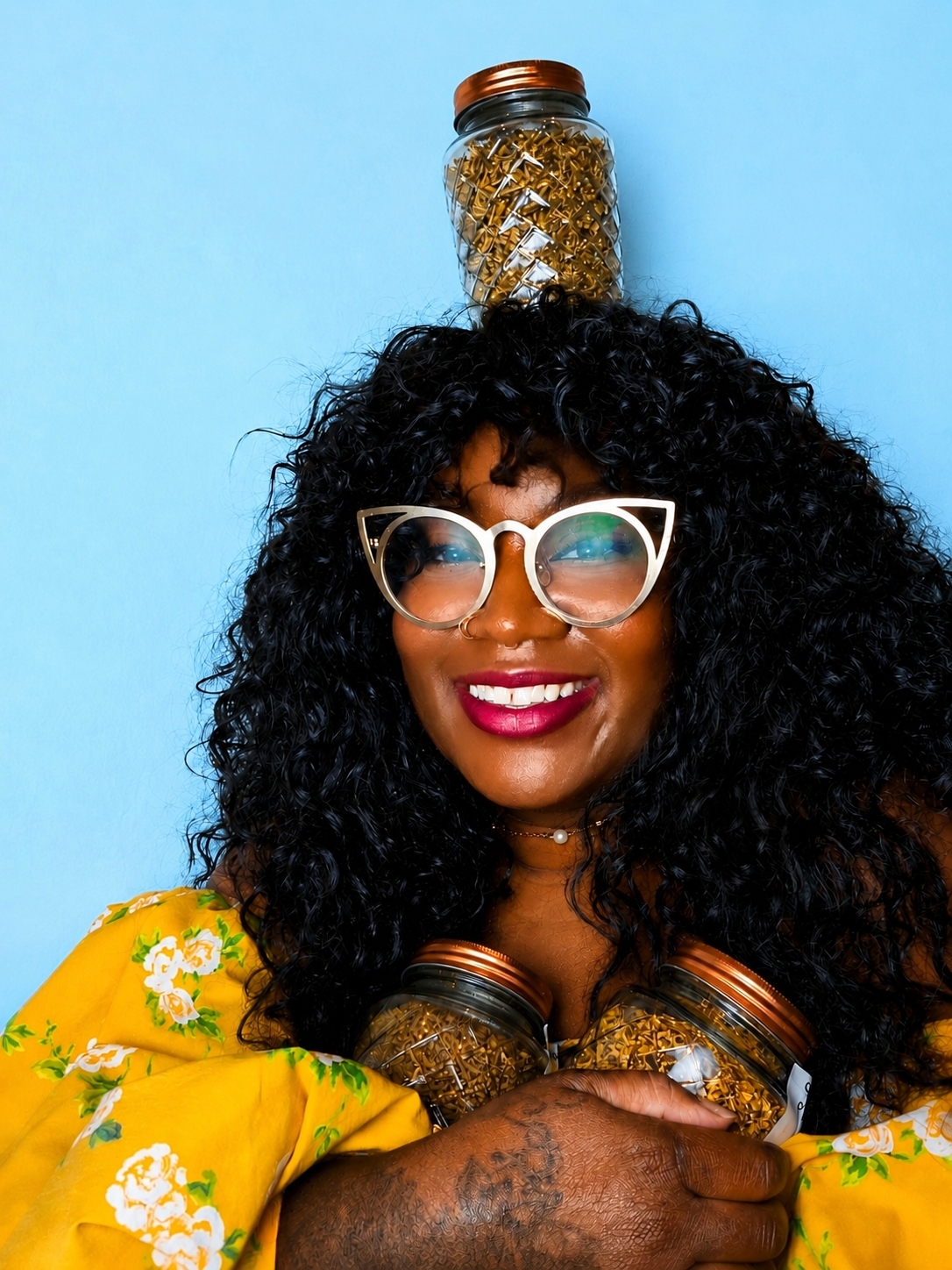 Yvette Nathalie Brown smiling with three glass jars, one balanced on her head